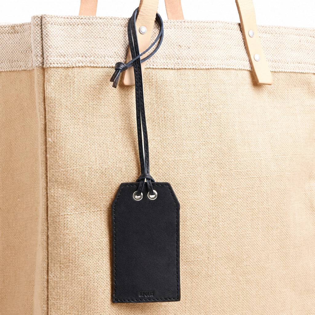 Black leather gift tag with note on an Apolis bag, blank front
