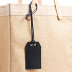 Black leather gift tag with note on an Apolis bag, blank front