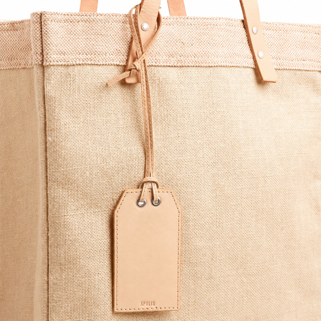 Natural leather gift tag with note on an Apolis bag, blank front
