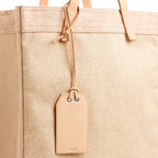 Natural leather gift tag with note on an Apolis bag, blank front